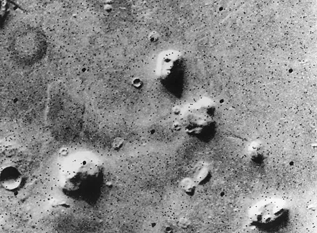  En 1976, el orbitador Viking 1 de la NASA capturó esta imagen de Marte. Las sombras proyectadas sobre la formación rocosa generan la ilusión de un rostro humano. Foto: NASA<br>  