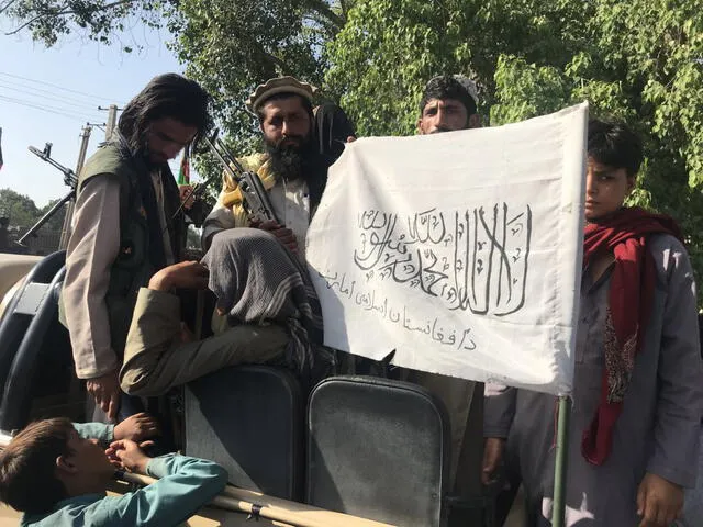 Militantes talibanes muestran su bandera. Foto: EFE