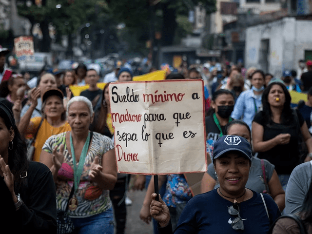 Ciudadanos esperan respuesta del régimen de Maduro ante el reclamo salarial. Foto: EFE   