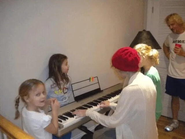 Taylor junto a las hijas de Jarrett tocando el piano, con el luchador observando. Foto: talkSPORT   