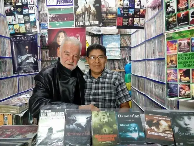  Béla Tarr durante su visita a Perú posando junto a copias de sus películas. Foto: Facebook   