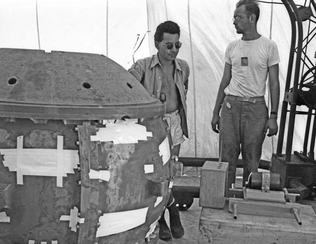 Louis Slotin (izquierda) posa de pie juto a la primera bomba nuclear, la cual está parcialmente ensamblada. Foto: Los Alamos National Laboratory