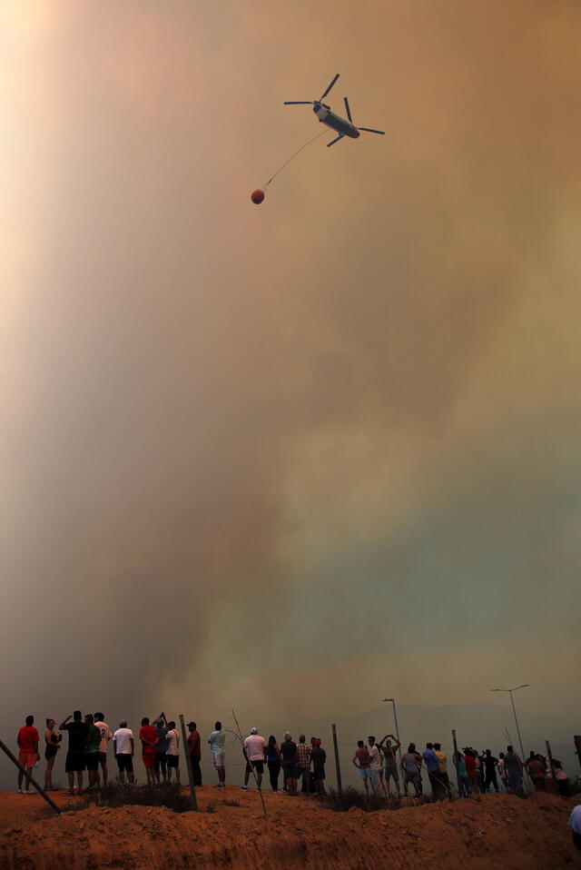 Un helicóptero apaga un incendio forestal que afecta a los cerros de la comuna de Quilpe, Región de Valparaíso. Foto: AFP   